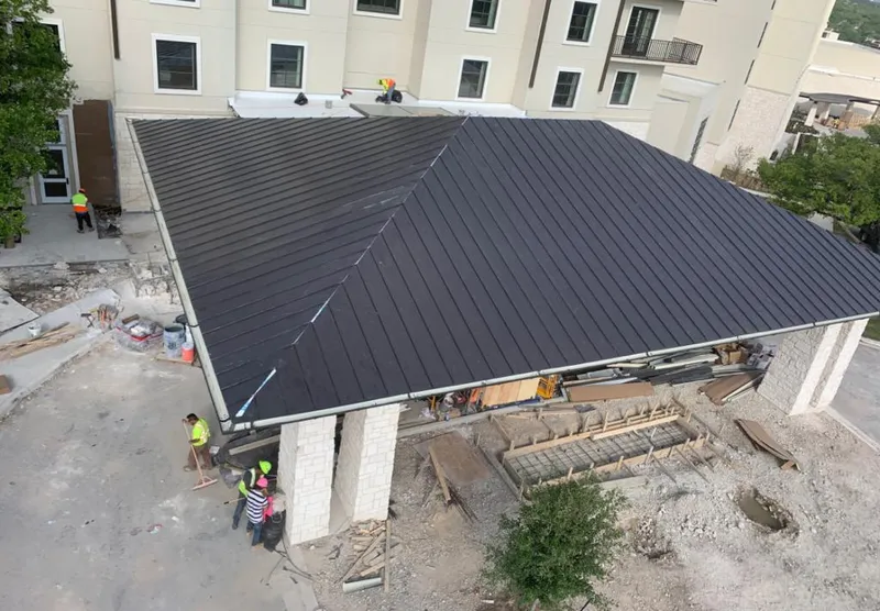 Metal roofing installation team working on a commercial building in Los Fresnos